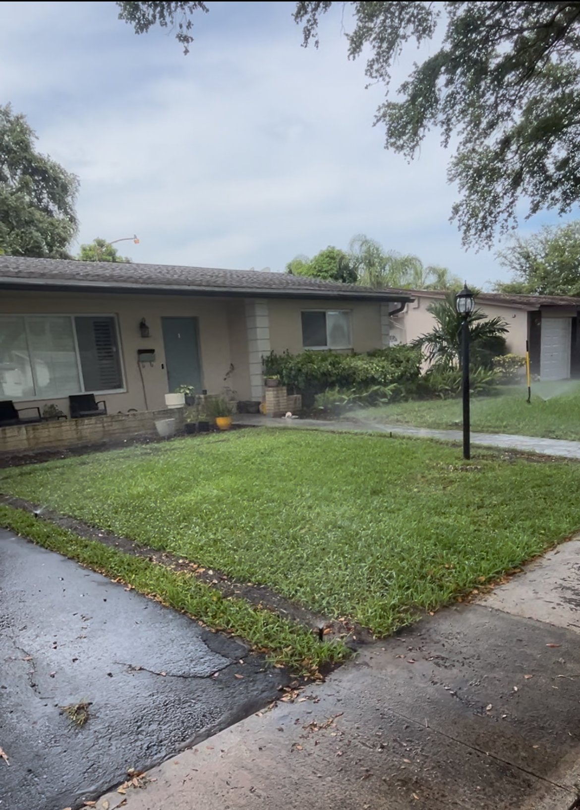 Lush residential lawn with active irrigation mist in Broward County, FL
