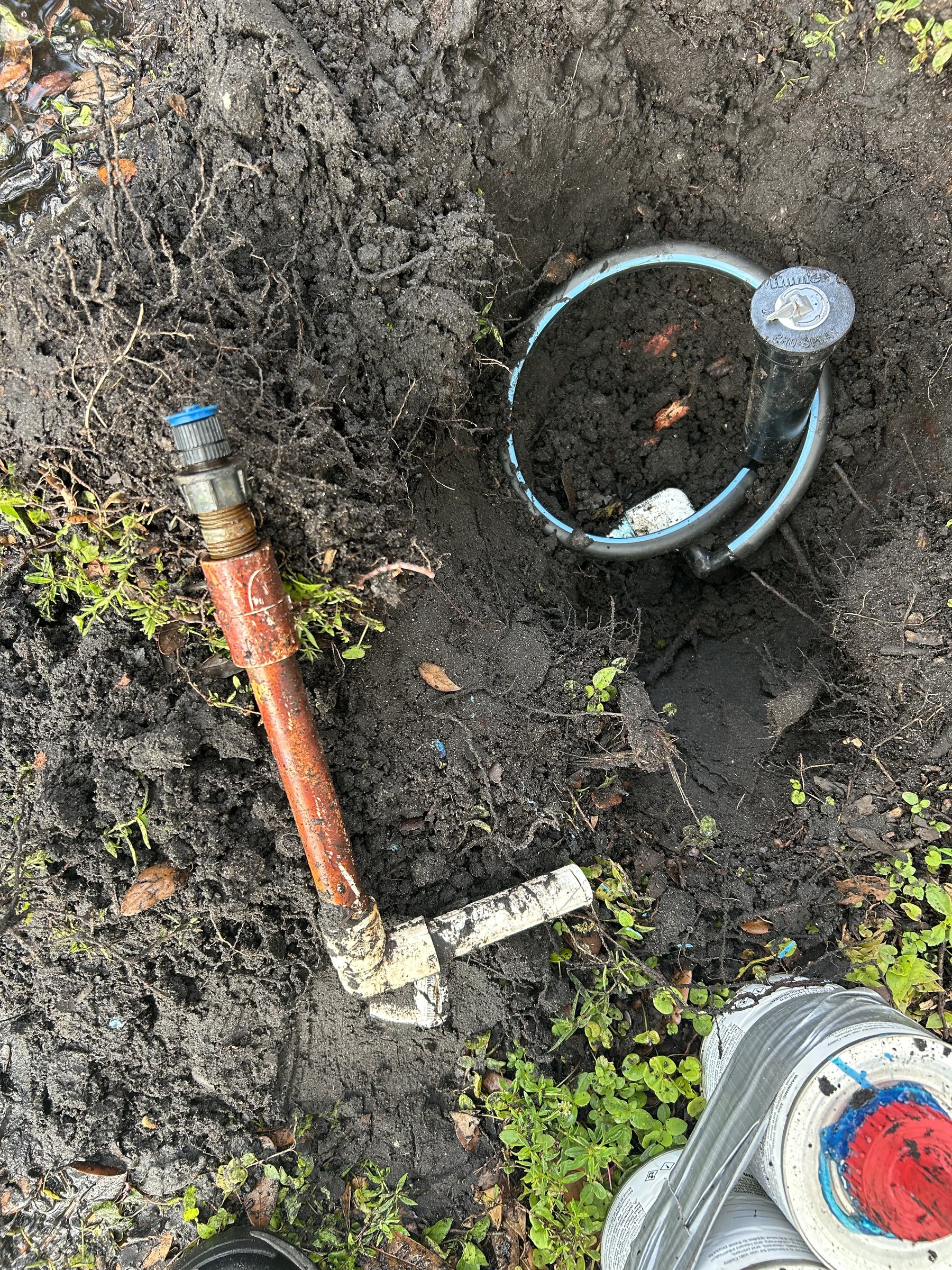 Excavated sprinkler assembly in soil for underground irrigation repair